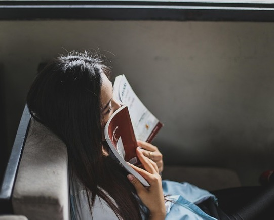 woman holding a book to her face